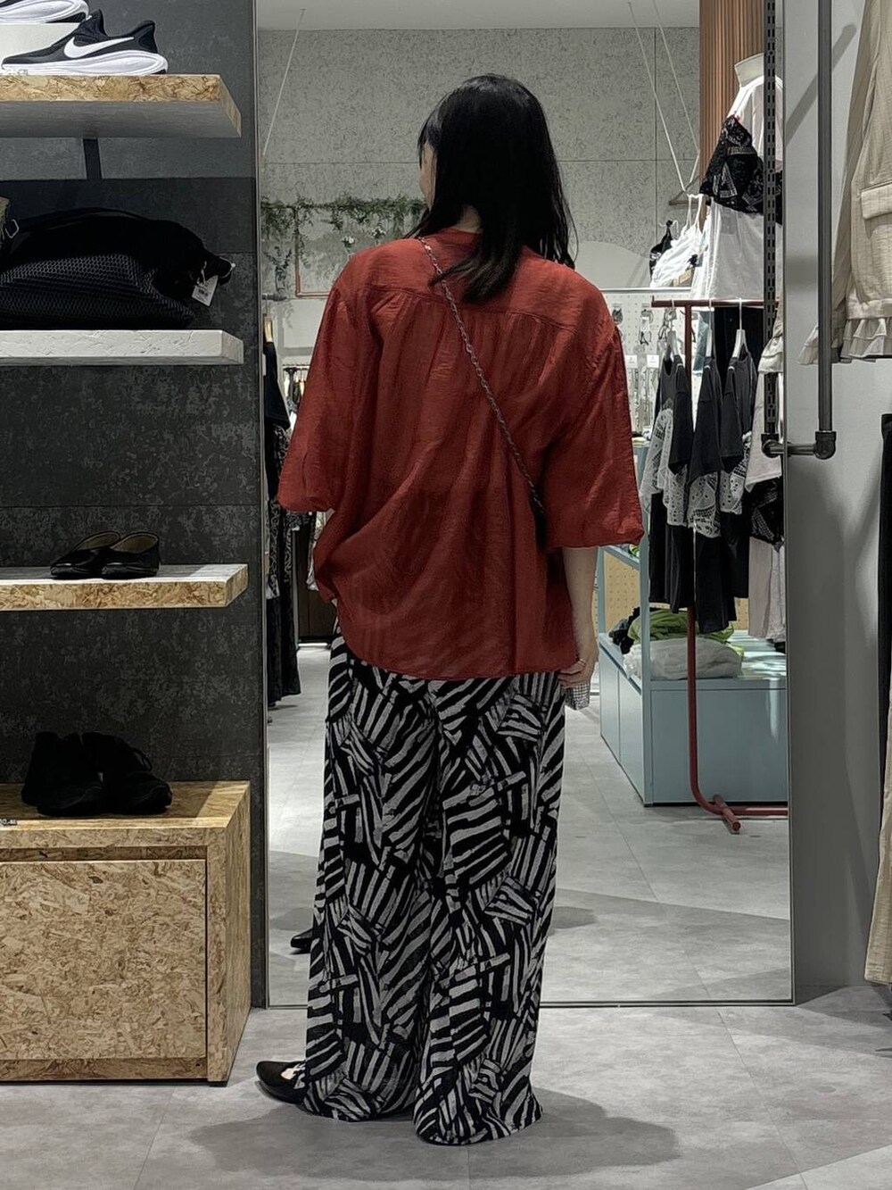 ブラック系のその他パンツ、レッド系のシャツ/ブラウス、シルバー系のショルダーバッグを着用したレディースの春コーディネートの4枚目の写真