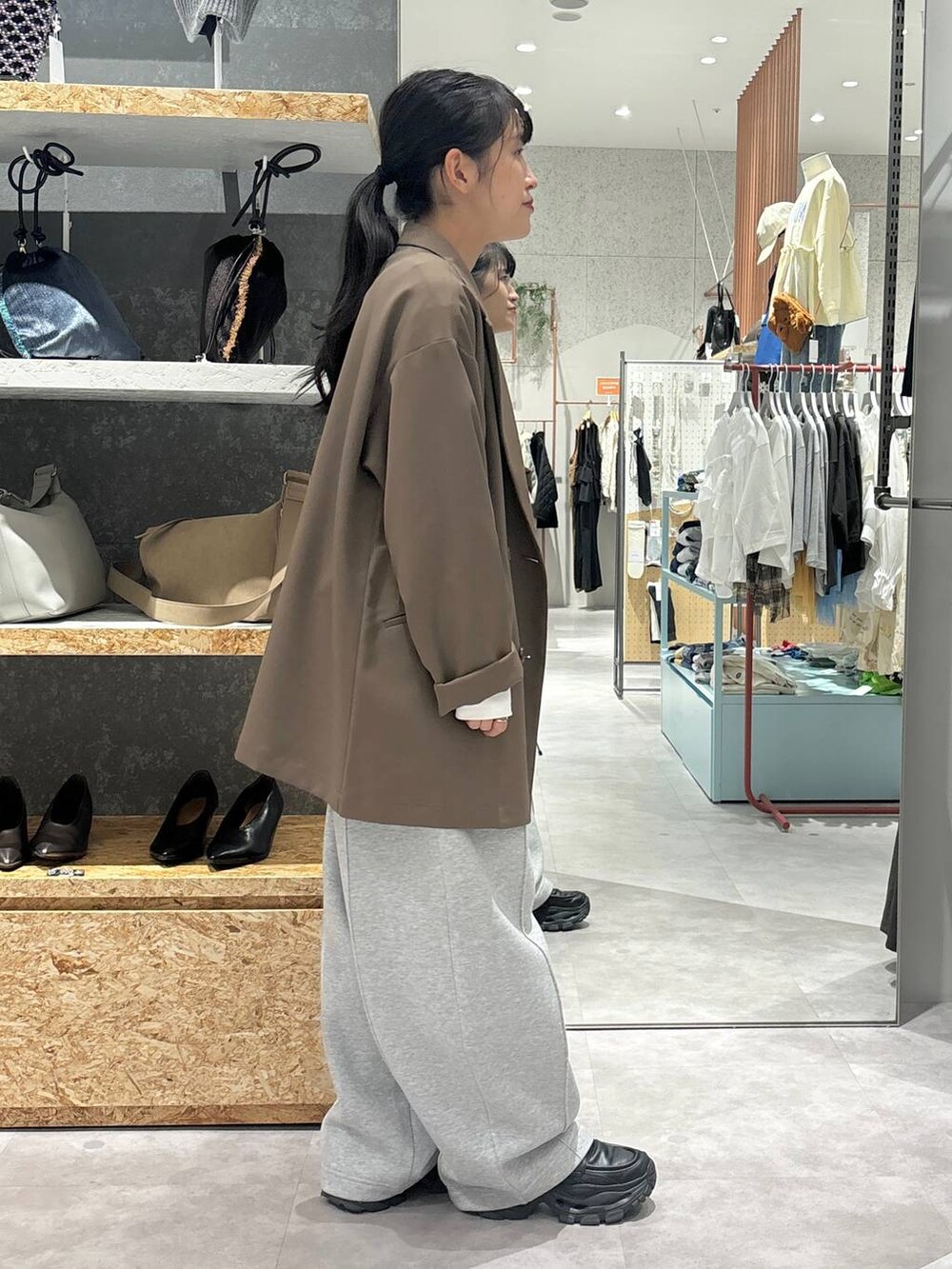 ブラック系のローファー、グレー系のスウェットパンツ、ブラウン系のテーラードジャケットを着用したレディースの秋コーディネートの5枚目の写真