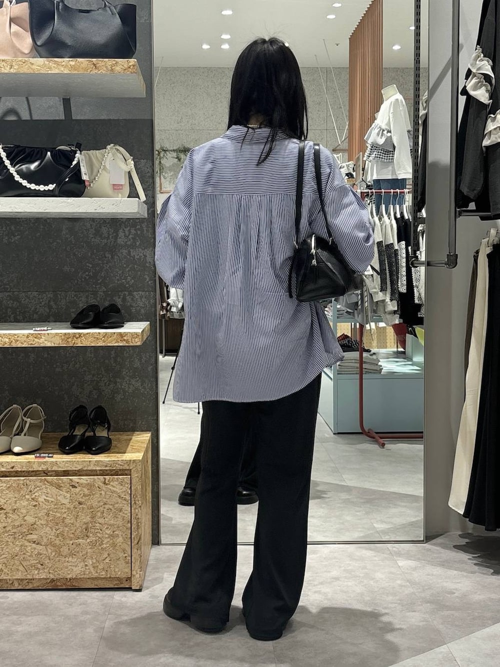 ブラック系のサンダル、ブラック系のボストンバッグ、ブルー系のシャツ/ブラウスを着用したレディースの冬コーディネートの4枚目の写真