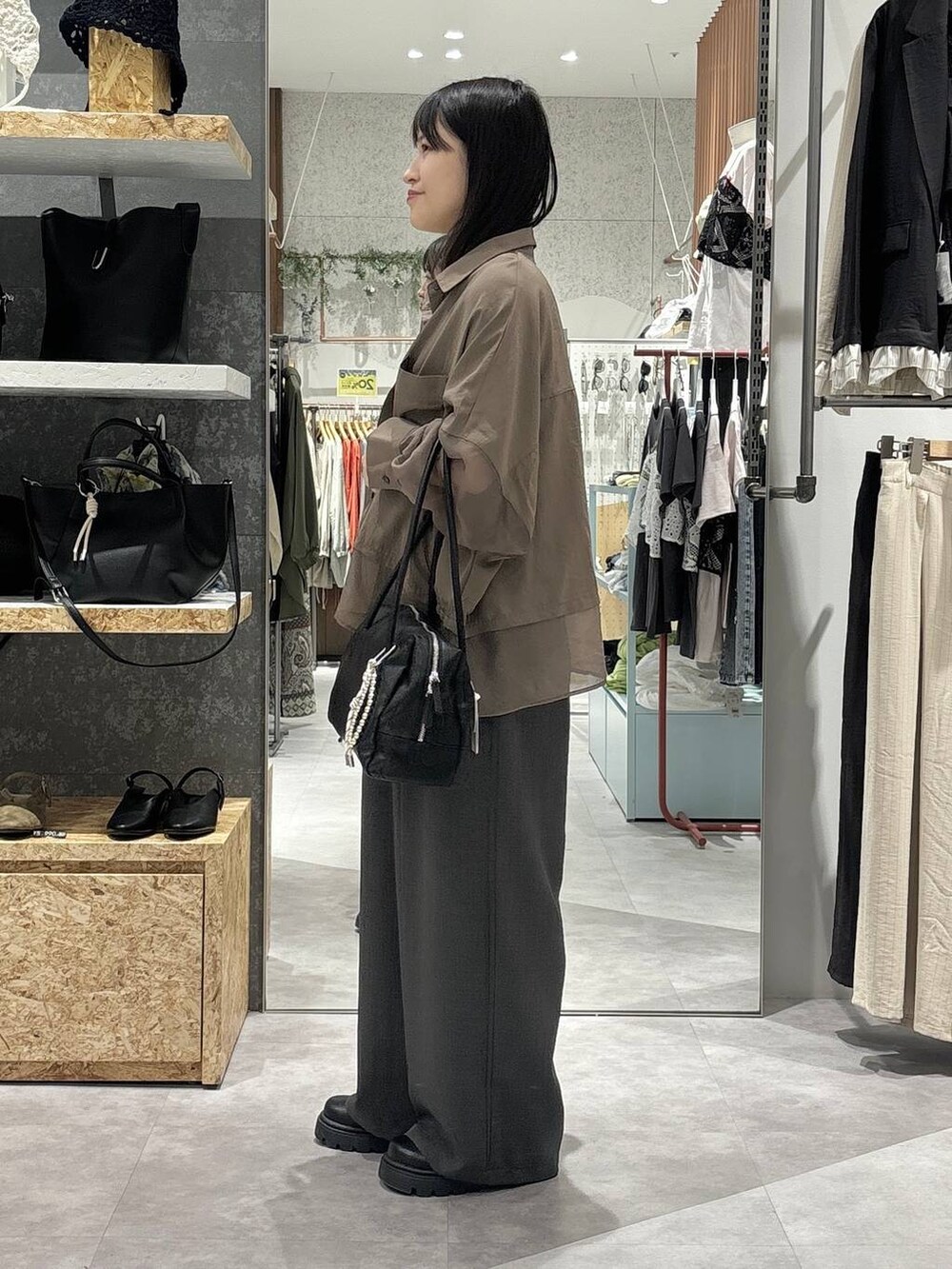 ブラック系のボストンバッグ、グレー系のその他パンツ、ホワイト系のタンクトップを着用したレディースの春コーディネートの3枚目の写真