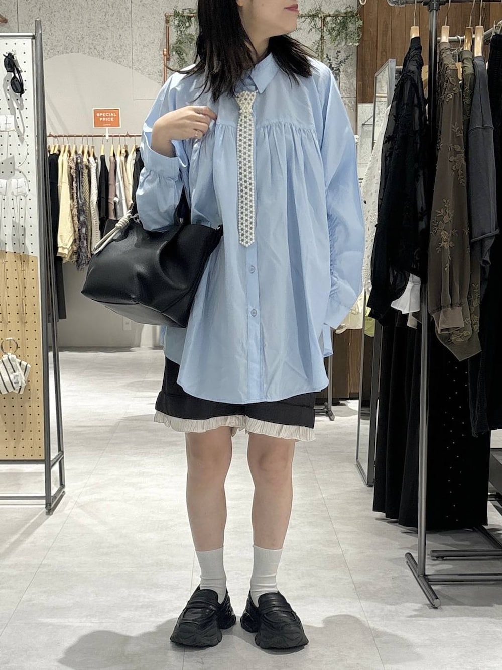 グレー系のその他パンツ、ブルー系のシャツ/ブラウス、ブラック系のトートバッグを着用したレディースの春コーディネートの2枚目の写真