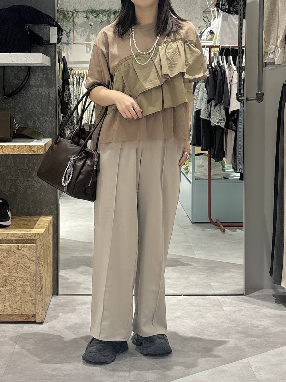 ブラウン系のボストンバッグ、ベージュ系のその他パンツ、ブラウン系のTシャツ/カットソーを着用したレディースの春コーディネートの2枚目の写真