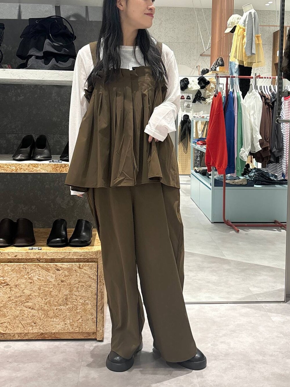 ブラック系のサンダル、ブラウン系のサロペット/オーバーオール、ホワイト系のTシャツ/カットソーを着用したレディースの秋コーディネートの2枚目の写真