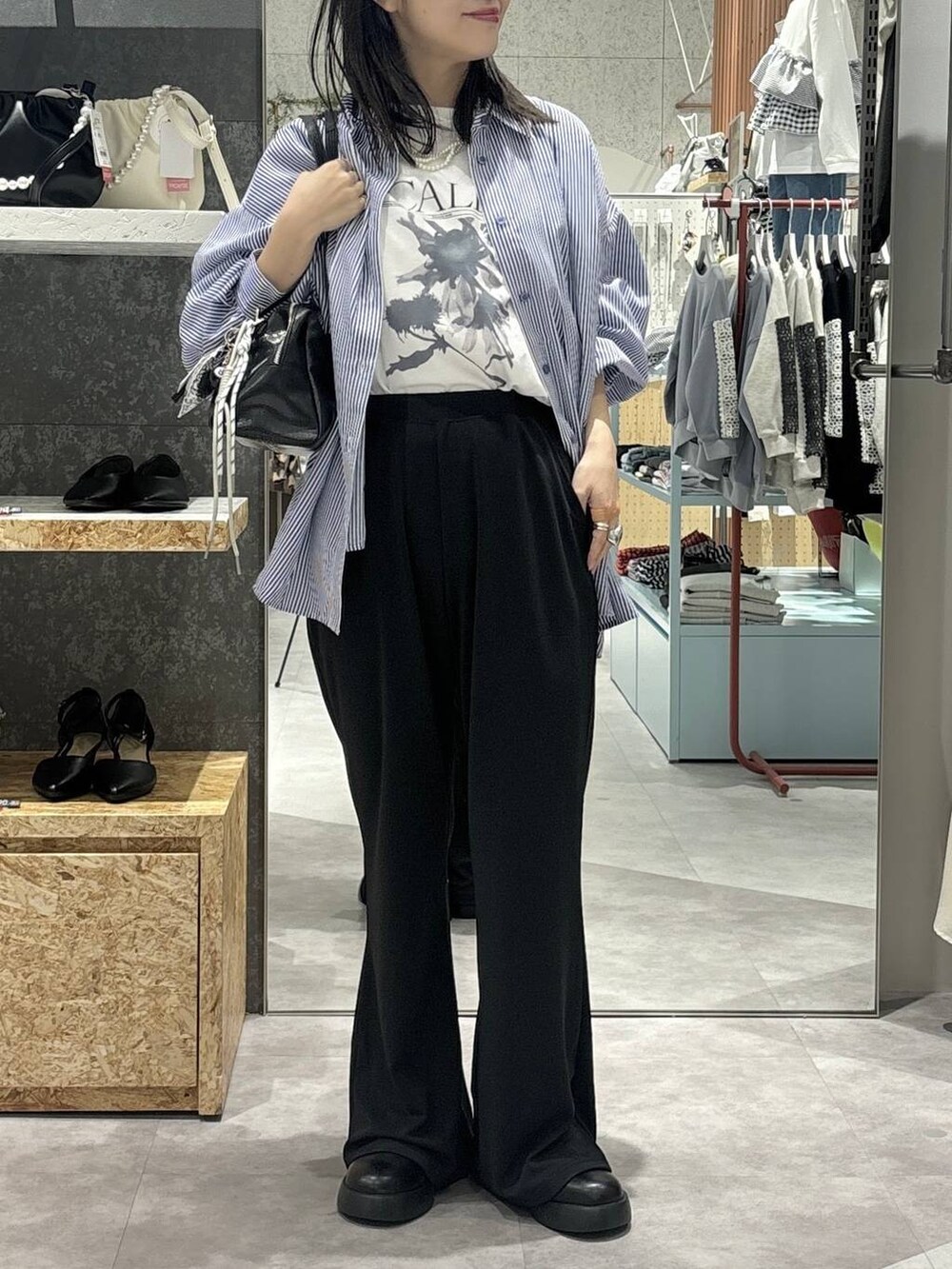 ブラック系のサンダル、ブラック系のボストンバッグ、ブルー系のシャツ/ブラウスを着用したレディースの冬コーディネートの2枚目の写真