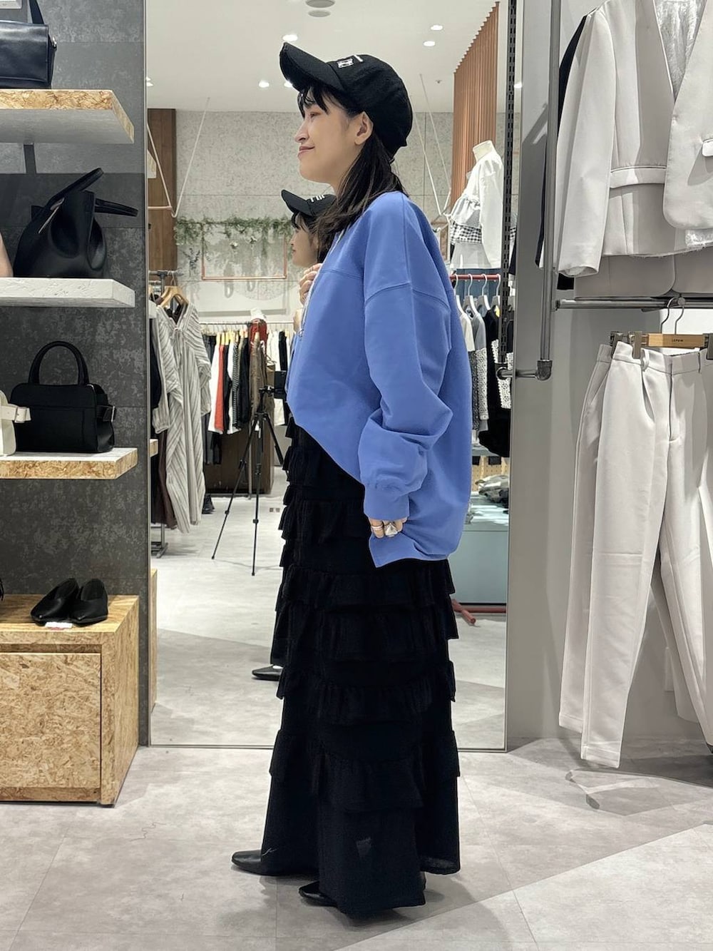 ブラック系のパンプス、ブルー系のTシャツ/カットソー、ブラック系のショルダーバッグを着用したレディースの春コーディネートの3枚目の写真