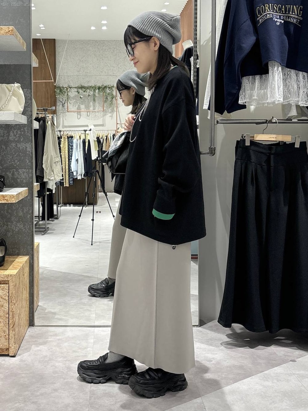 グレー系のスカート、ブラック系のローファー、ブラック系のボストンバッグを着用したレディースの冬コーディネートの3枚目の写真