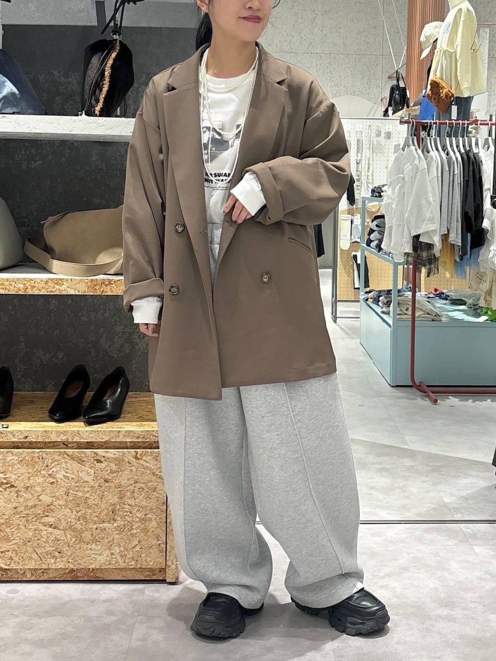 ブラック系のローファー、グレー系のスウェットパンツ、ブラウン系のテーラードジャケットを着用したレディースの秋コーディネートの2枚目の写真