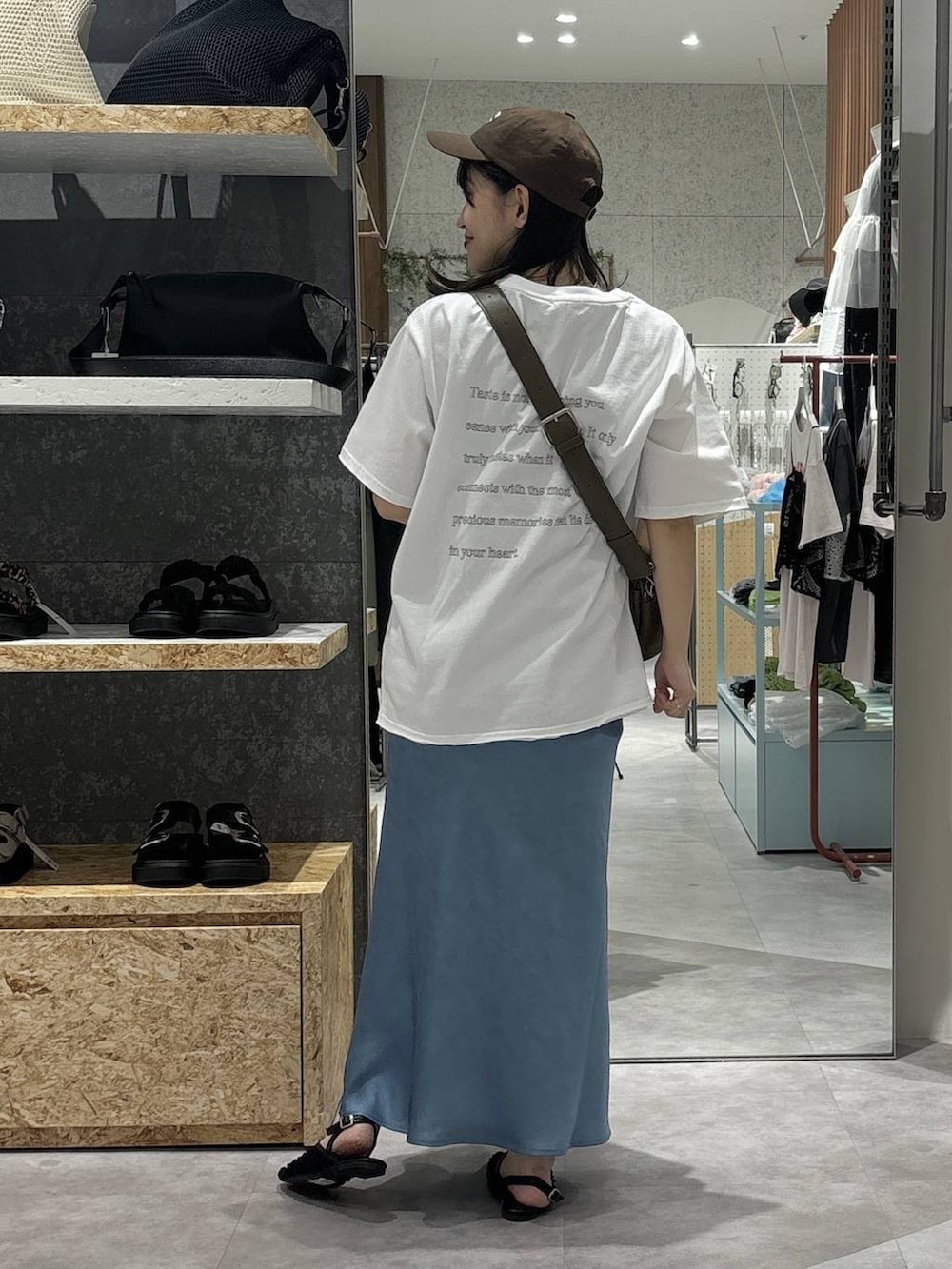 ブラウン系のショルダーバッグ、ブルー系のスカート、ブラック系のパンプスを着用したレディースの春コーディネートの3枚目の写真