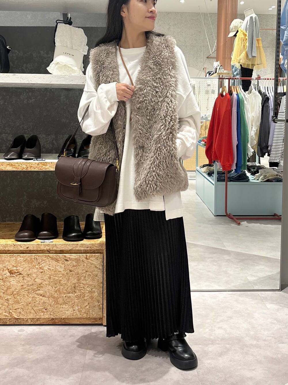 ブラック系のサンダル、ブラウン系のショルダーバッグ、ブラック系のスカートを着用したレディースの秋コーディネートの2枚目の写真