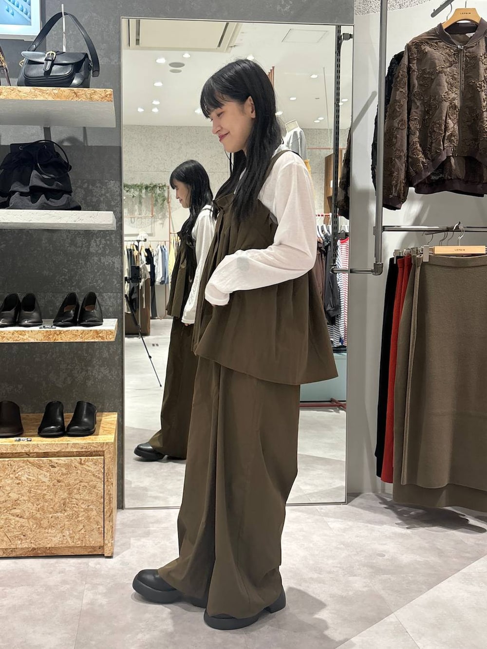 ブラック系のサンダル、ブラウン系のサロペット/オーバーオール、ホワイト系のTシャツ/カットソーを着用したレディースの秋コーディネートの4枚目の写真