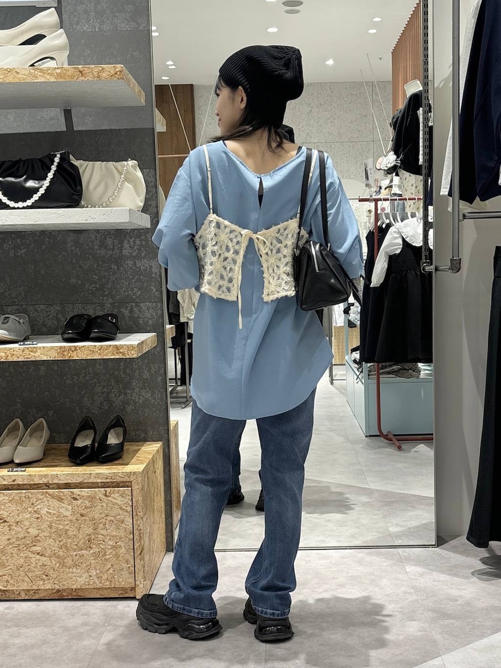 ブラック系のローファー、ブラック系のボストンバッグ、ブルー系のシャツ/ブラウスを着用したレディースの冬コーディネートの4枚目の写真