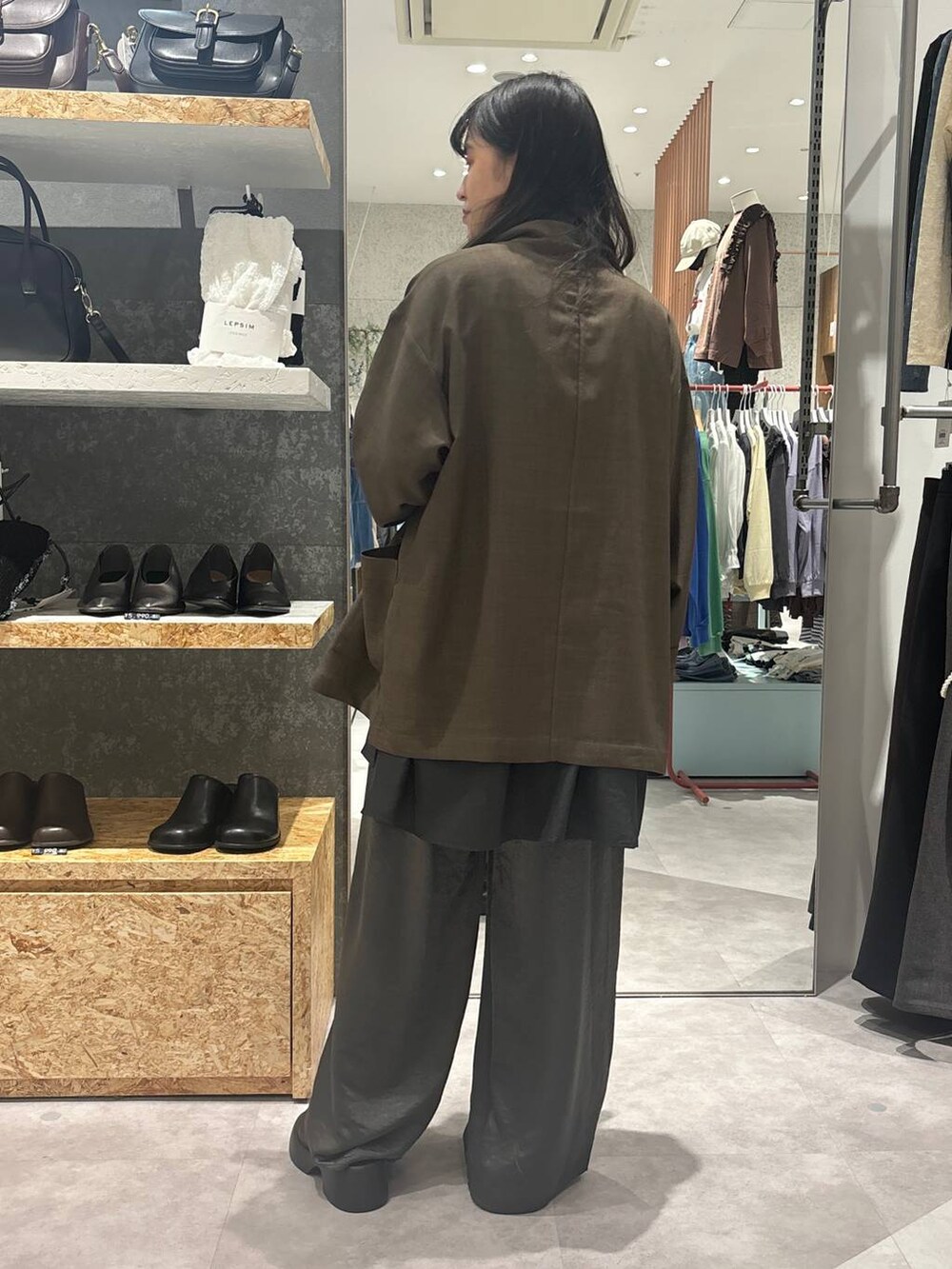 ブラック系のサンダル、グレー系のシャツ/ブラウス、ブラウン系のテーラードジャケットを着用したレディースの冬コーディネートの4枚目の写真