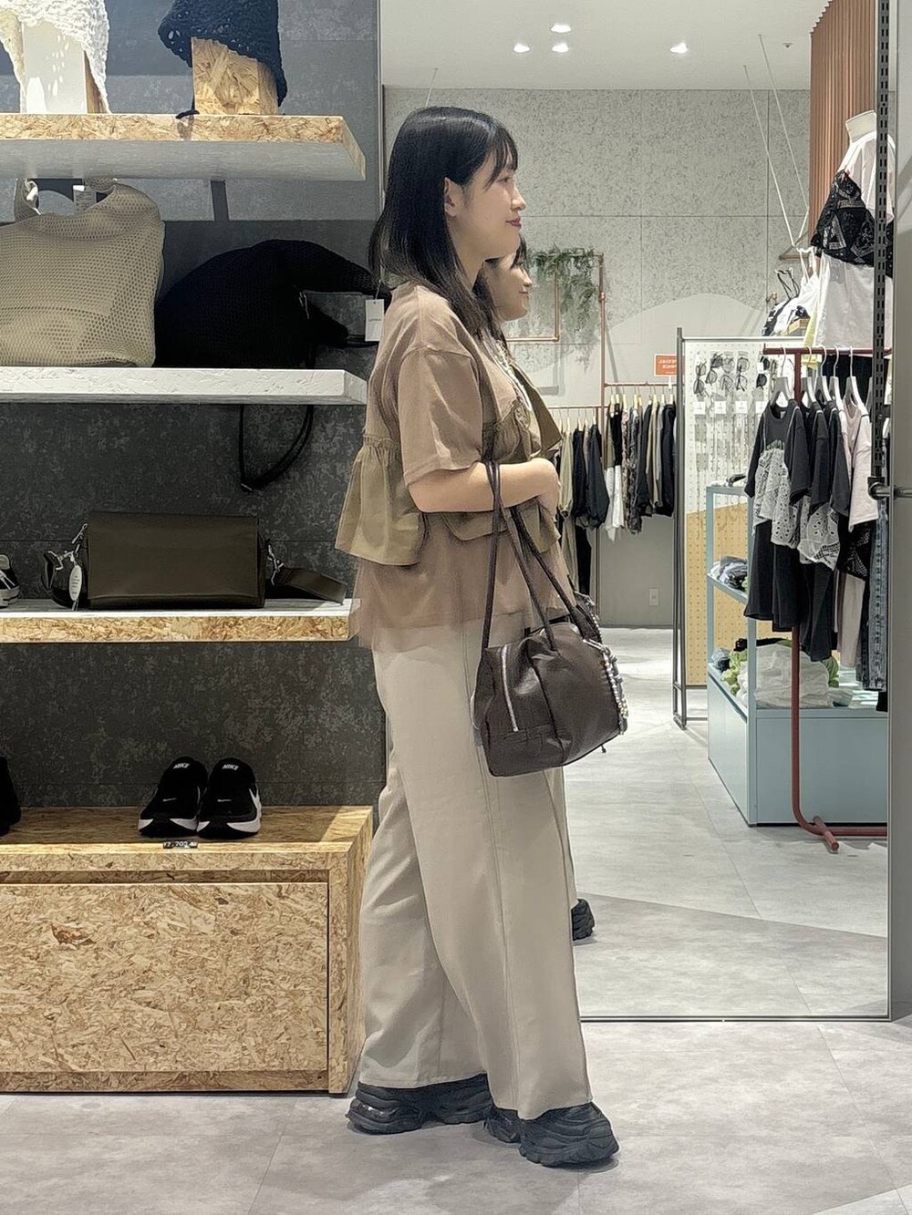ブラウン系のボストンバッグ、ベージュ系のその他パンツ、ブラウン系のTシャツ/カットソーを着用したレディースの春コーディネートの3枚目の写真