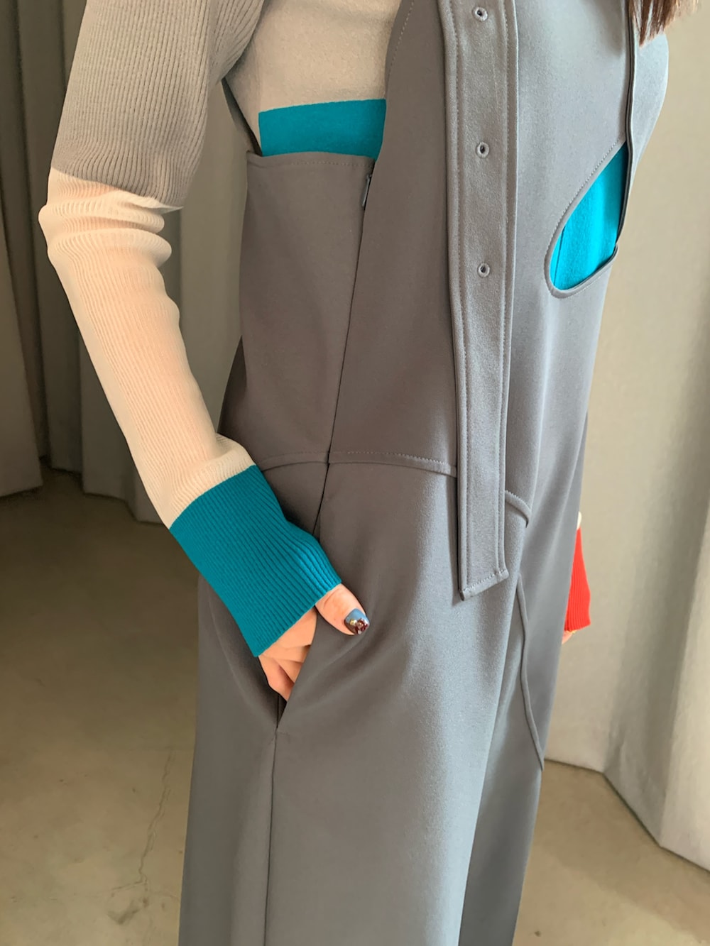 グレー系のつなぎ/オールインワン、オレンジ系のニット/セーターを着用したレディースの冬コーディネートの5枚目の写真