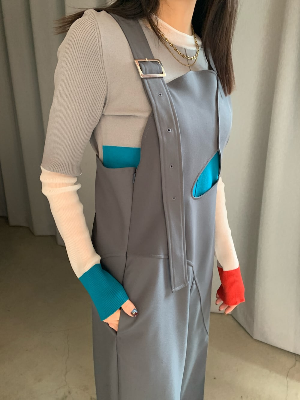 グレー系のつなぎ/オールインワン、オレンジ系のニット/セーターを着用したレディースの冬コーディネートの4枚目の写真