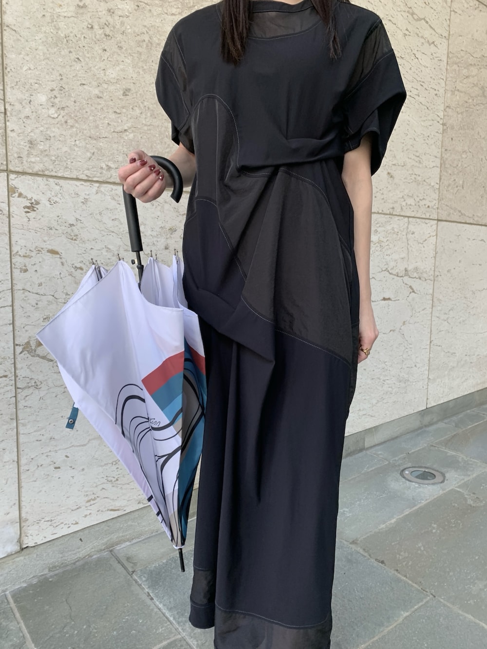 ブラック系のワンピース、グレー系のサンダル、ホワイト系の長傘を着用したレディースの春コーディネートの4枚目の写真