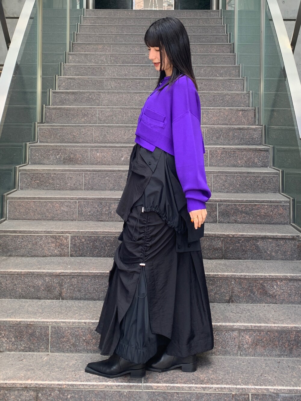 ブラック系のスカート、ブラック系のシャツ/ブラウス、パープル系のカーディガン/ボレロを着用したレディースの夏コーディネートの2枚目の写真