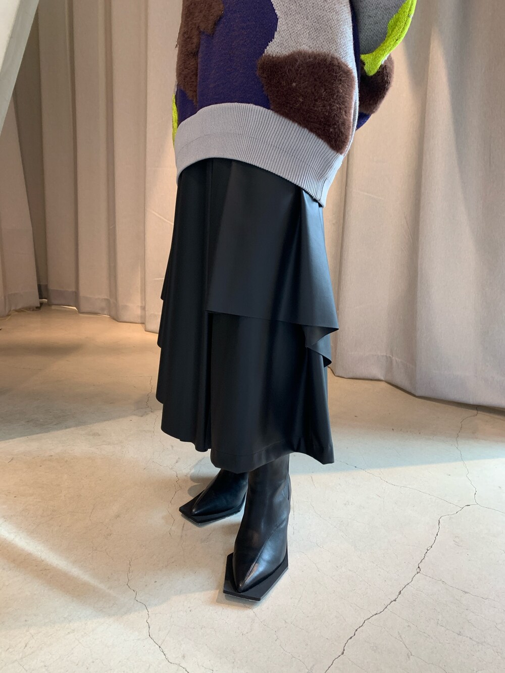 グレー系のニット/セーター、ブラック系のその他パンツ、ブラック系のブーツを着用したレディースの冬コーディネートの5枚目の写真