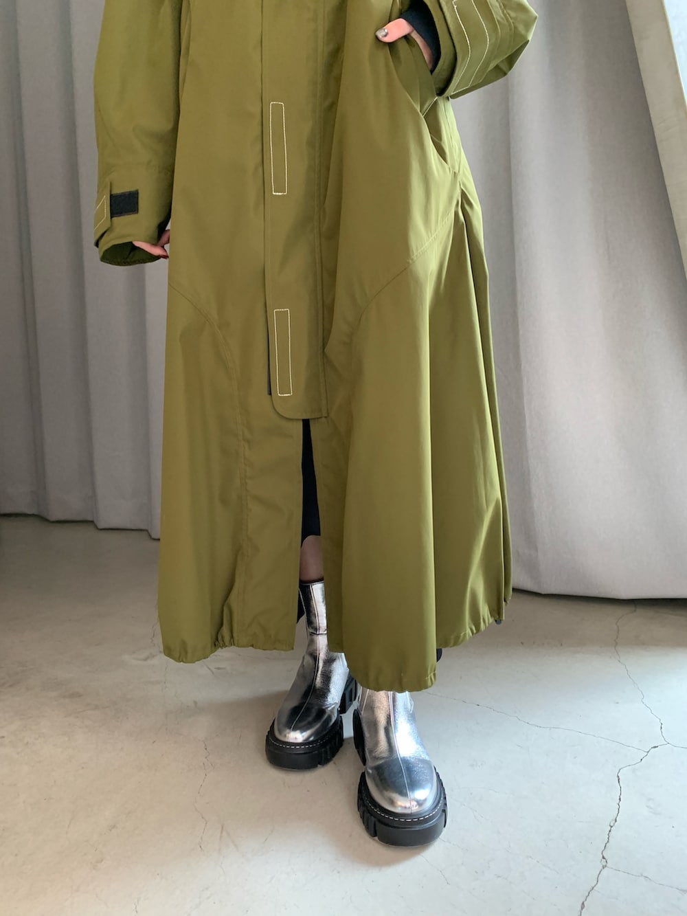 グリーン系のその他アウター、シルバー系のブーツを着用したレディースの冬コーディネートの5枚目の写真