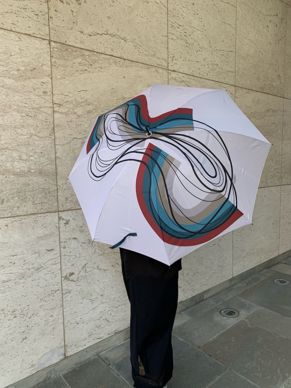 ブラック系のワンピース、グレー系のサンダル、ホワイト系の長傘を着用したレディースの春コーディネートの3枚目の写真