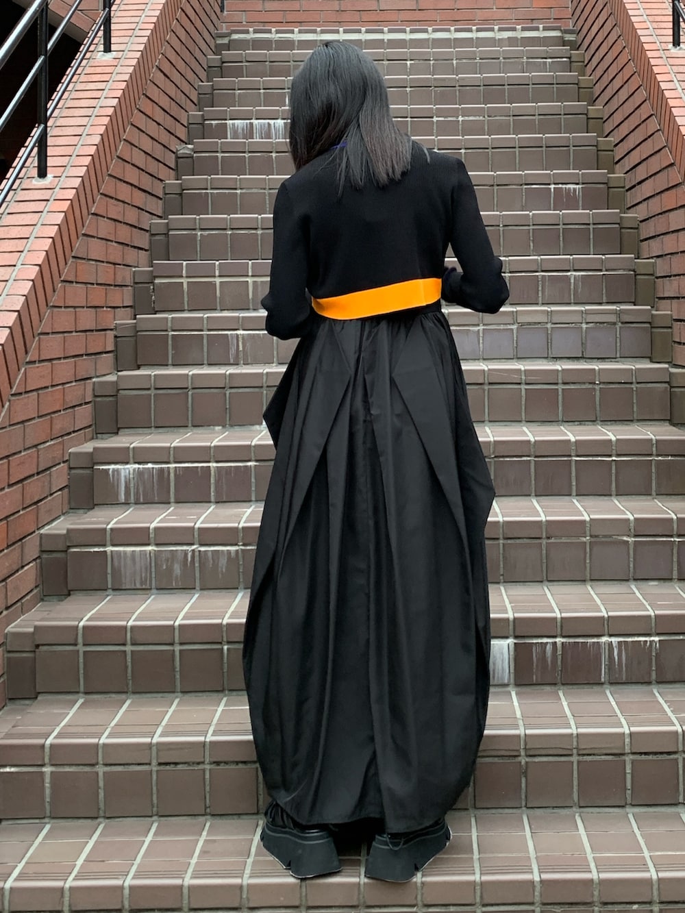 ブラック系のワンピース、ブラック系のサンダル、ブラック系のカーディガン/ボレロを着用したレディースの春コーディネートの2枚目の写真