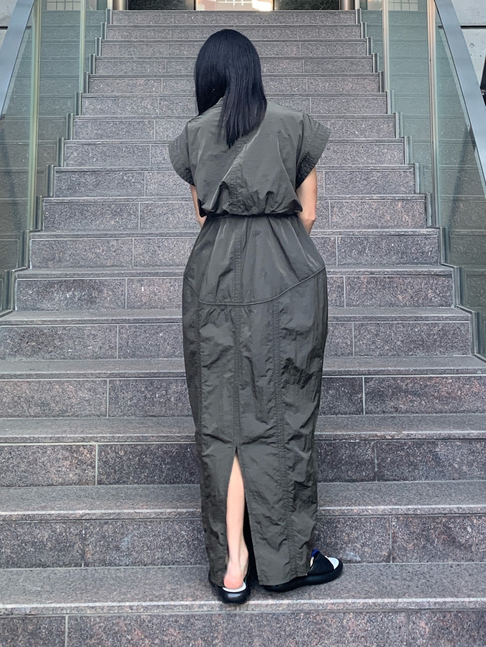 グリーン系のワンピース、その他のサンダル、ゴールド系のピアス（両耳用）を着用したレディースの春コーディネートの3枚目の写真