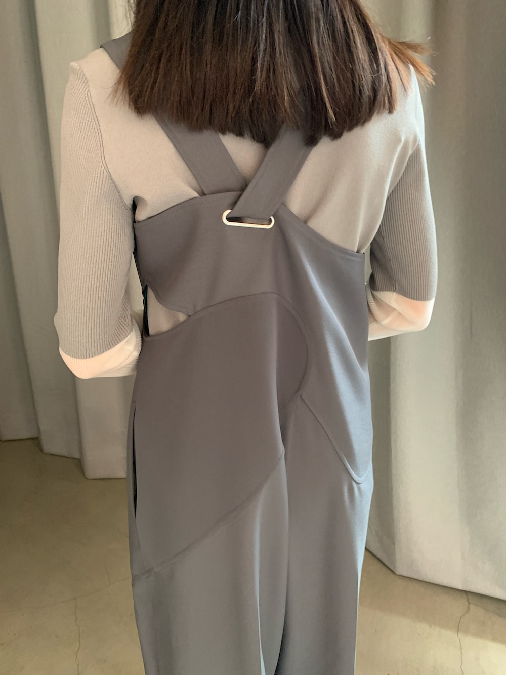 グレー系のつなぎ/オールインワン、オレンジ系のニット/セーターを着用したレディースの冬コーディネートの6枚目の写真