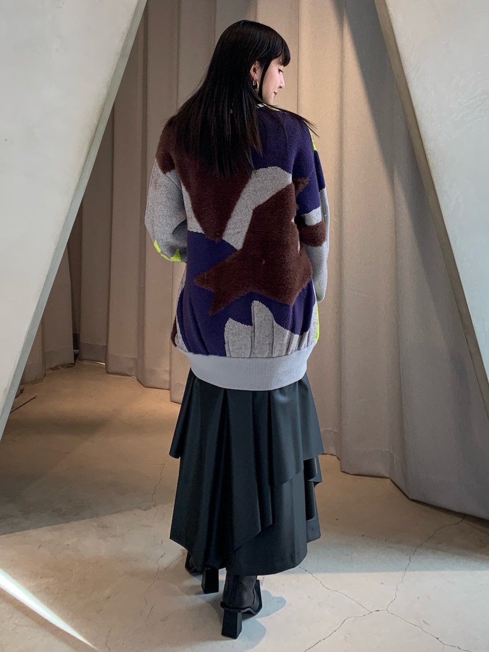 グレー系のニット/セーター、ブラック系のその他パンツ、ブラック系のブーツを着用したレディースの冬コーディネートの2枚目の写真