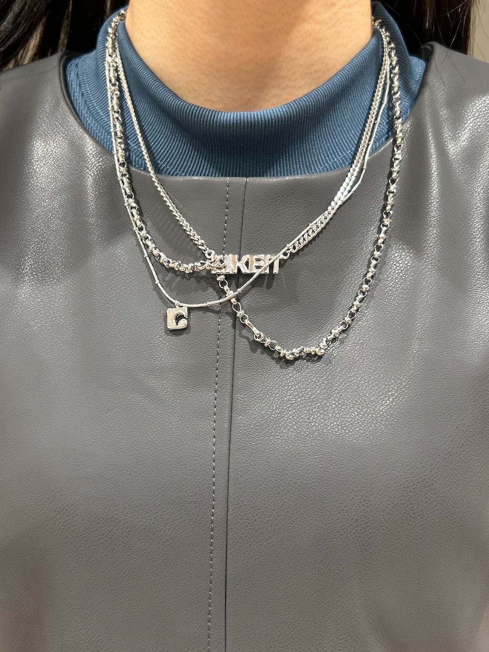 グレー系のワンピース、グレー系のハンドバッグ、ブルー系のデニムパンツを着用したレディースの夏コーディネートの8枚目の写真