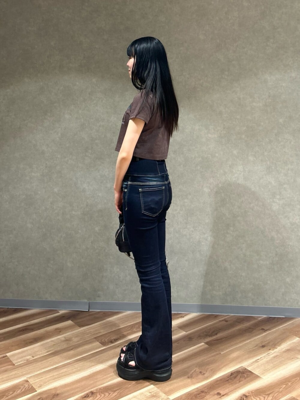 ブラック系のサンダル、ブラウン系のTシャツ/カットソー、ブルー系のデニムパンツを着用したレディースの夏コーディネートの3枚目の写真