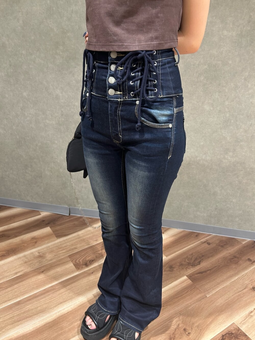 ブラック系のサンダル、ブラウン系のTシャツ/カットソー、ブルー系のデニムパンツを着用したレディースの夏コーディネートの6枚目の写真