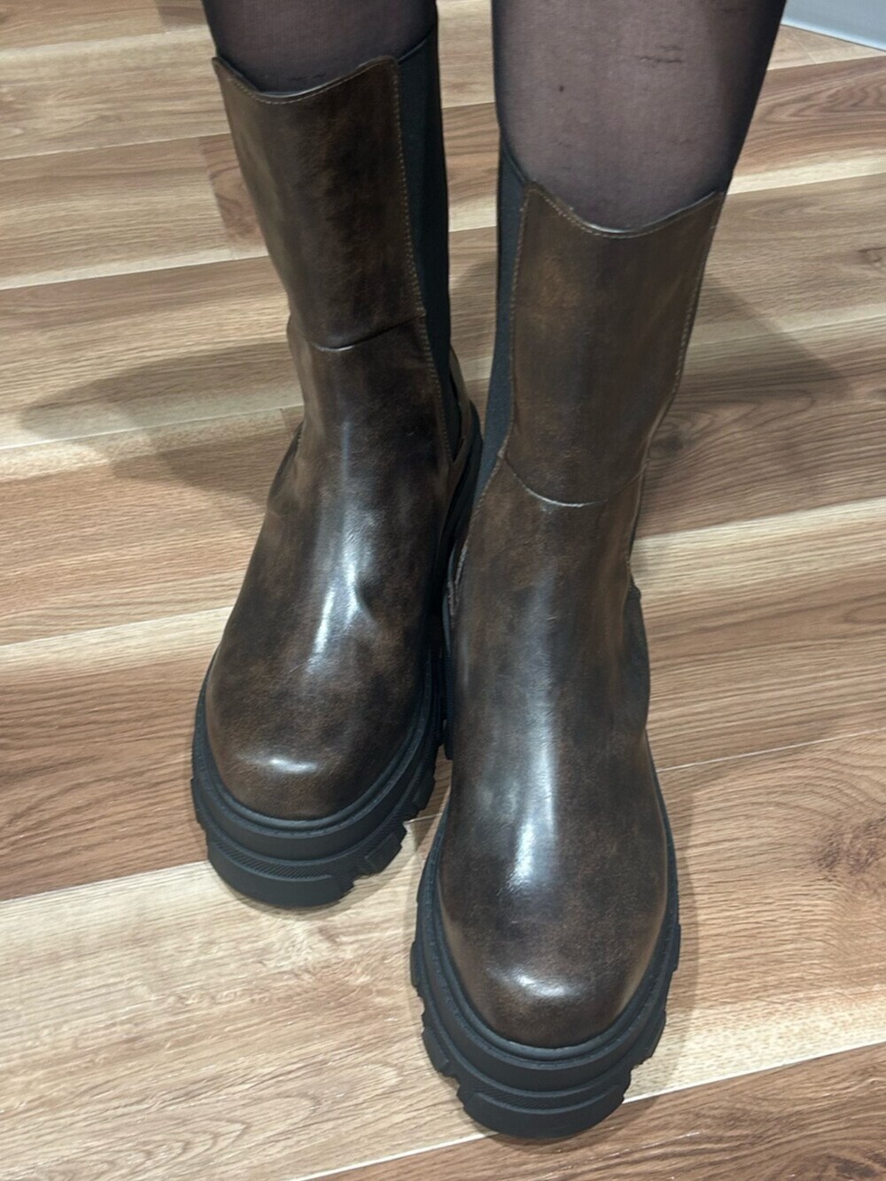 ブラック系のニット/セーター、グリーン系のワンピース、ブラウン系のブーツを着用したレディースの夏コーディネートの6枚目の写真