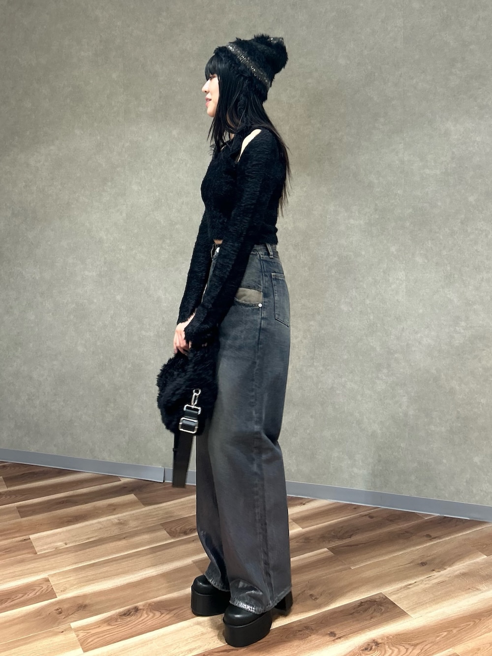 ブラック系のニット/セーター、ブラック系のブーツ、ブラック系のハンドバッグを着用したレディースの冬コーディネートの3枚目の写真