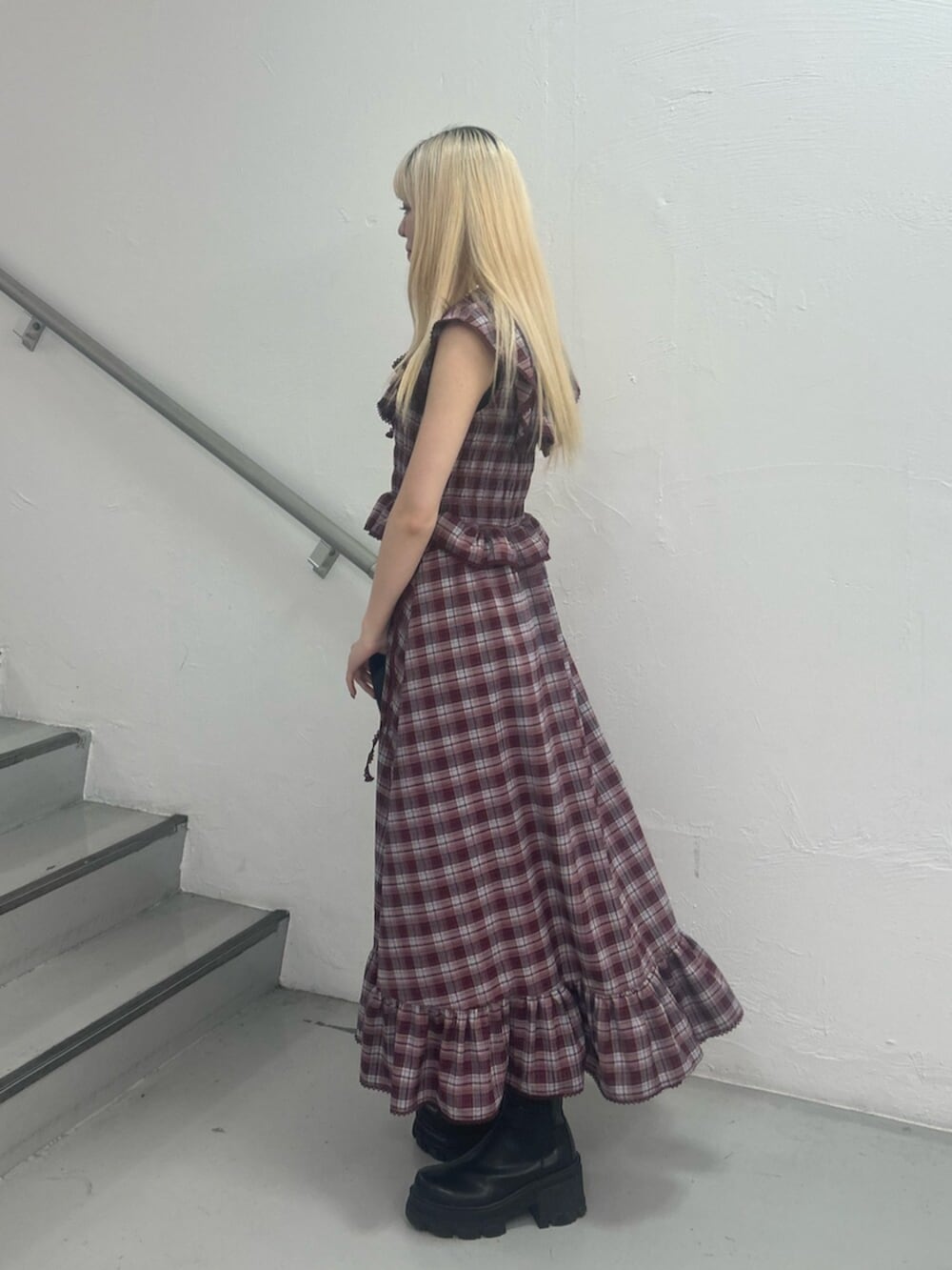 ブラック系のハンドバッグ、レッド系のワンピース、シルバー系のネックレスを着用したレディースの春コーディネートの3枚目の写真