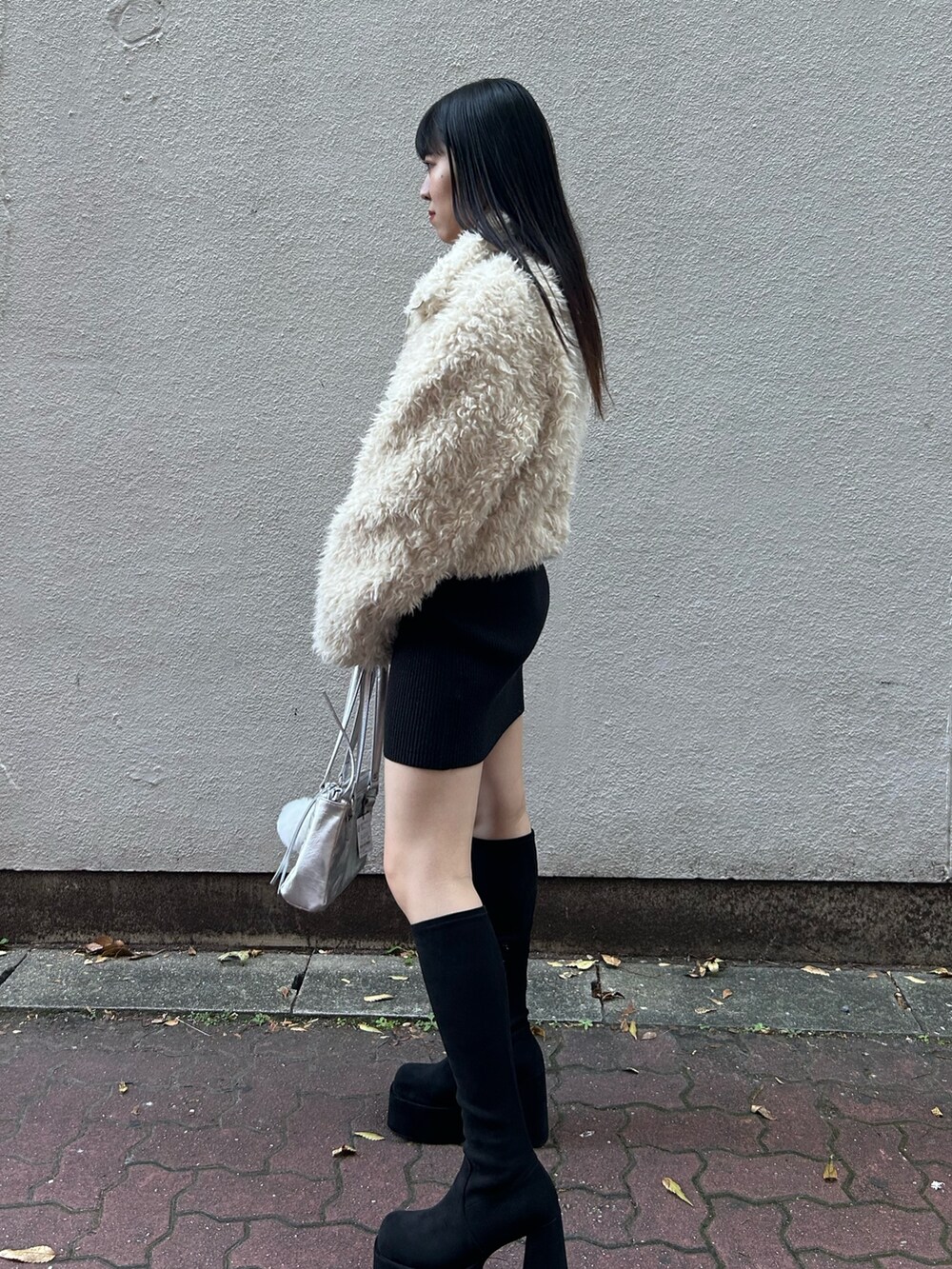 ホワイト系のブルゾン、ブラック系のワンピース、シルバー系のショルダーバッグを着用したレディースの秋コーディネートの3枚目の写真