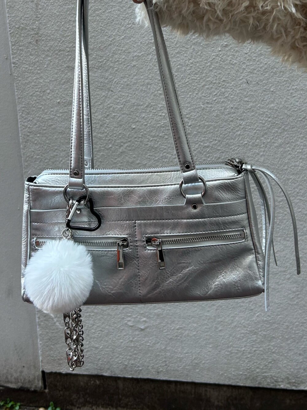 ホワイト系のブルゾン、ブラック系のワンピース、シルバー系のショルダーバッグを着用したレディースの秋コーディネートの7枚目の写真