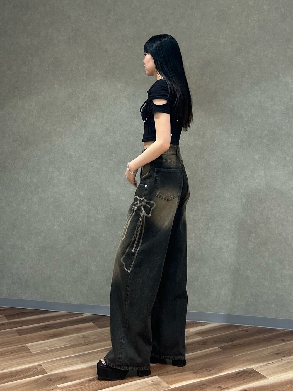 ブラック系のTシャツ/カットソー、ブラック系のデニムパンツ、ブラック系のサンダルを着用したレディースの夏コーディネートの2枚目の写真