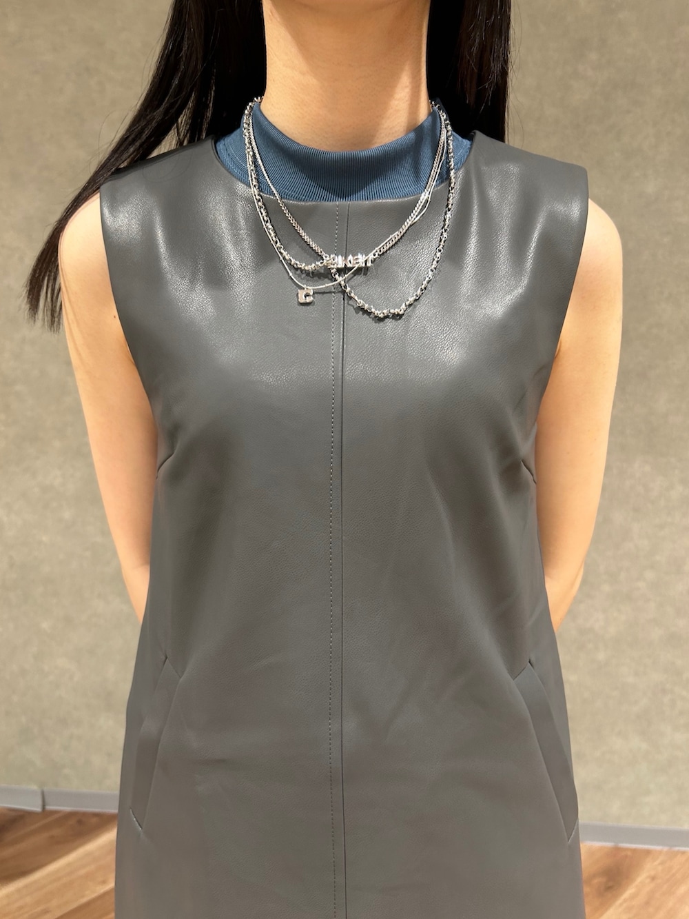 グレー系のワンピース、グレー系のハンドバッグ、ブルー系のデニムパンツを着用したレディースの夏コーディネートの5枚目の写真