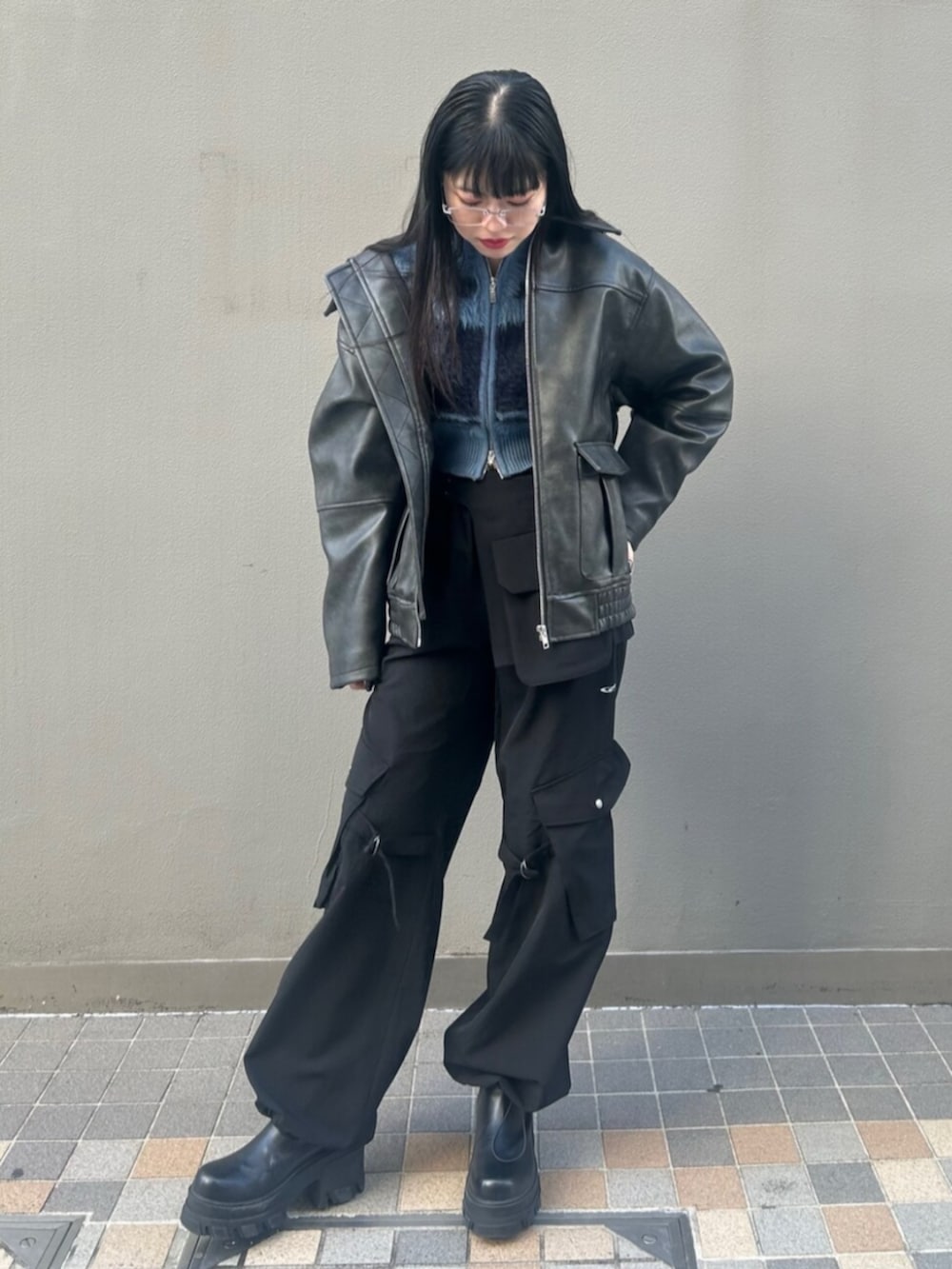 ブラック系のブーツ、ブラック系のブルゾン、ブルー系のニット/セーターを着用したレディースの冬コーディネートの2枚目の写真