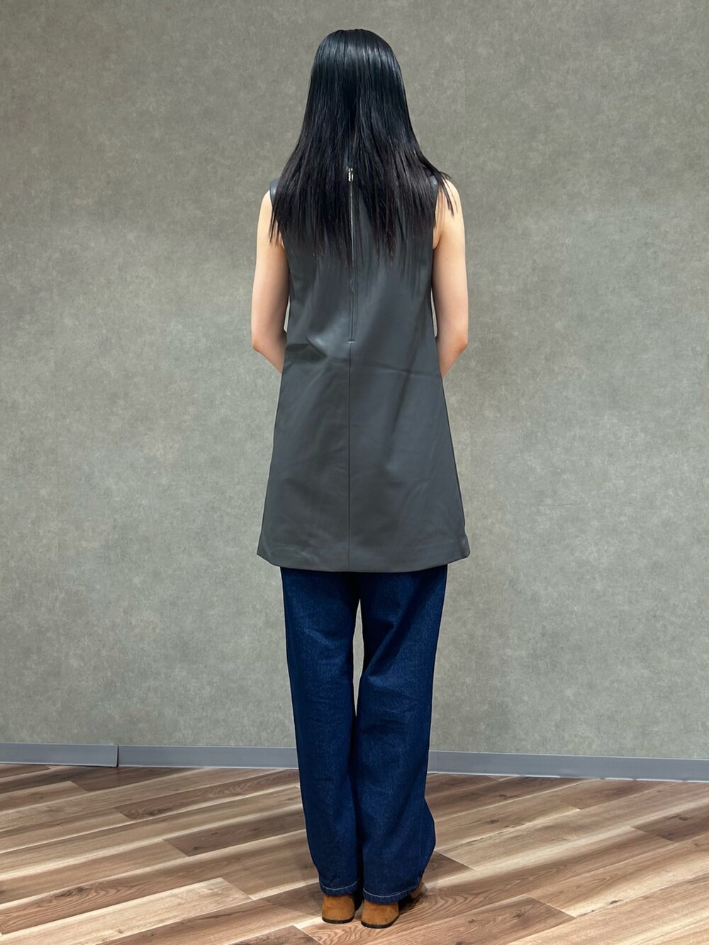 グレー系のワンピース、グレー系のハンドバッグ、ブルー系のデニムパンツを着用したレディースの夏コーディネートの4枚目の写真