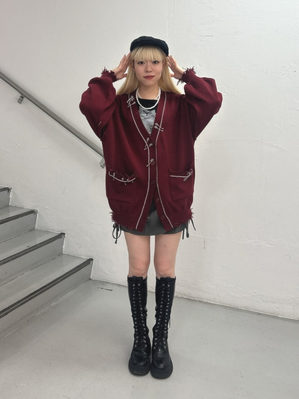ブラック系のTシャツ/カットソー、レッド系のカーディガン/ボレロ、グレー系のスカートを着用したレディースの秋コーディネートの2枚目の写真
