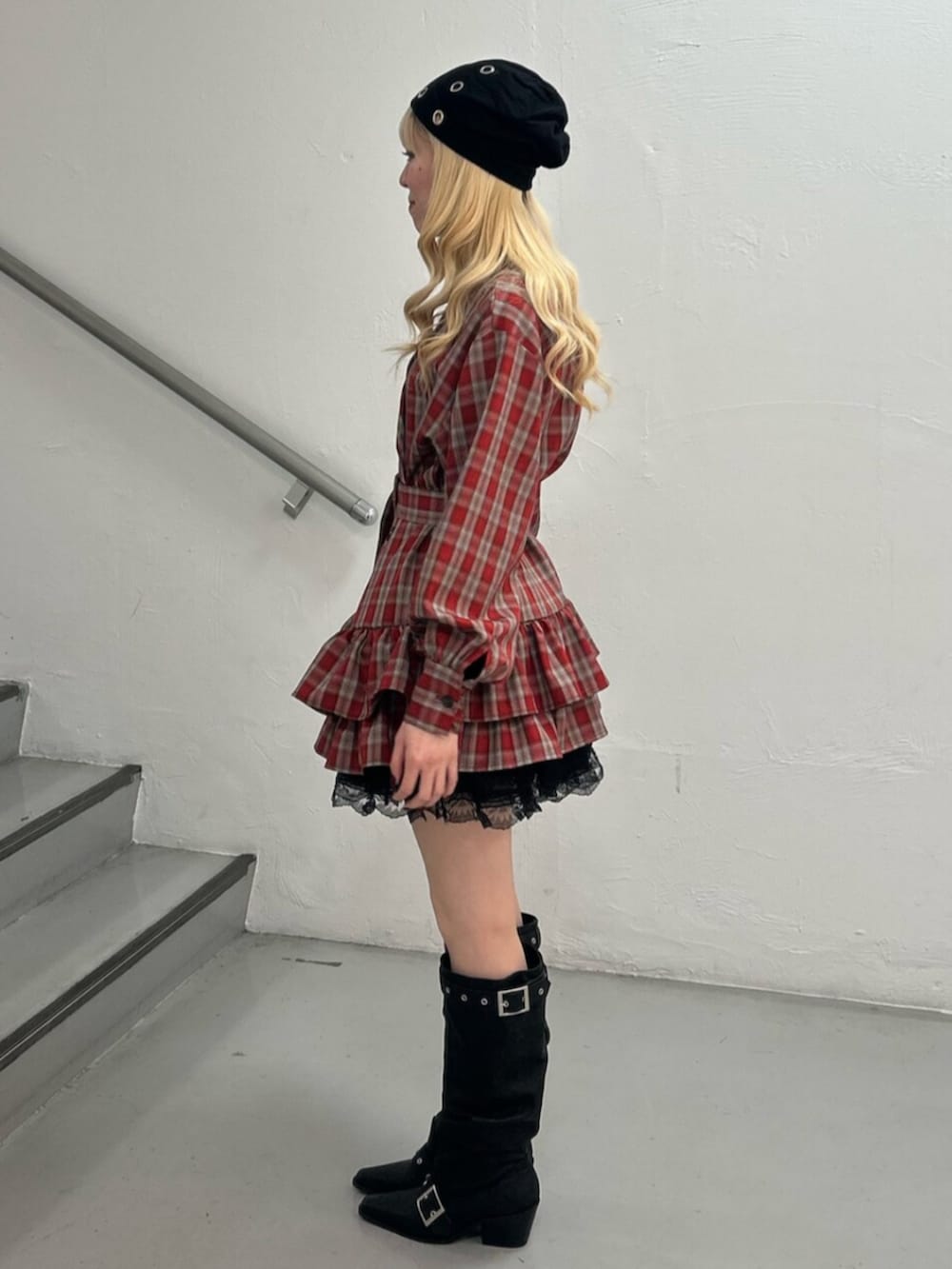 レッド系のワンピース、ブラック系のその他パンツ、ブラック系のブーツを着用したレディースの冬コーディネートの2枚目の写真