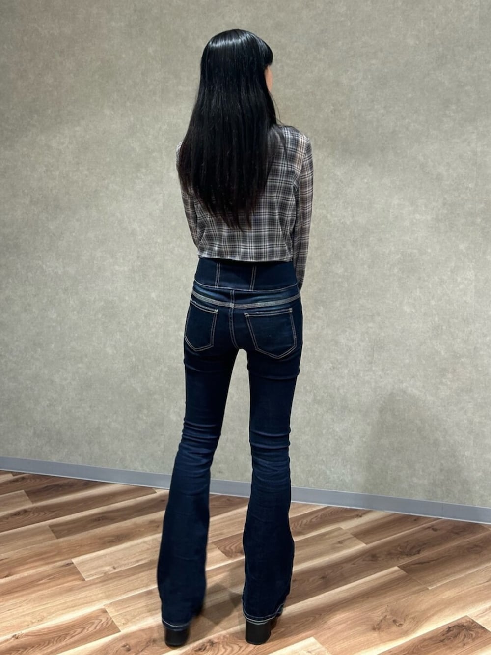 ブラック系のブーツ、ブラック系のニット/セーター、ブルー系のデニムパンツを着用したレディースの秋コーディネートの4枚目の写真