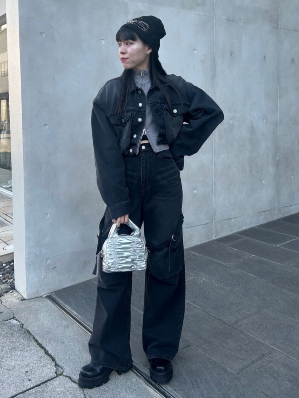 ブラック系のブーツ、ブラック系のデニムジャケット、ブラック系のデニムパンツを着用したレディースの冬コーディネートの2枚目の写真