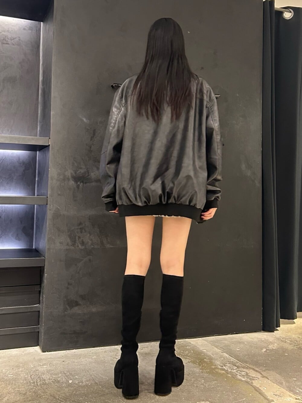 ブラック系のブルゾン、ブラック系のTシャツ/カットソー、ホワイト系のスカートを着用したレディースの秋コーディネートの4枚目の写真