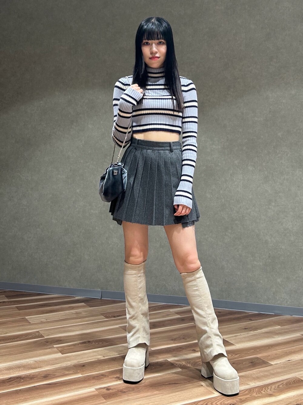 グレー系のハンドバッグ、その他のニット/セーター、グレー系のスカートを着用したレディースの秋コーディネートの2枚目の写真