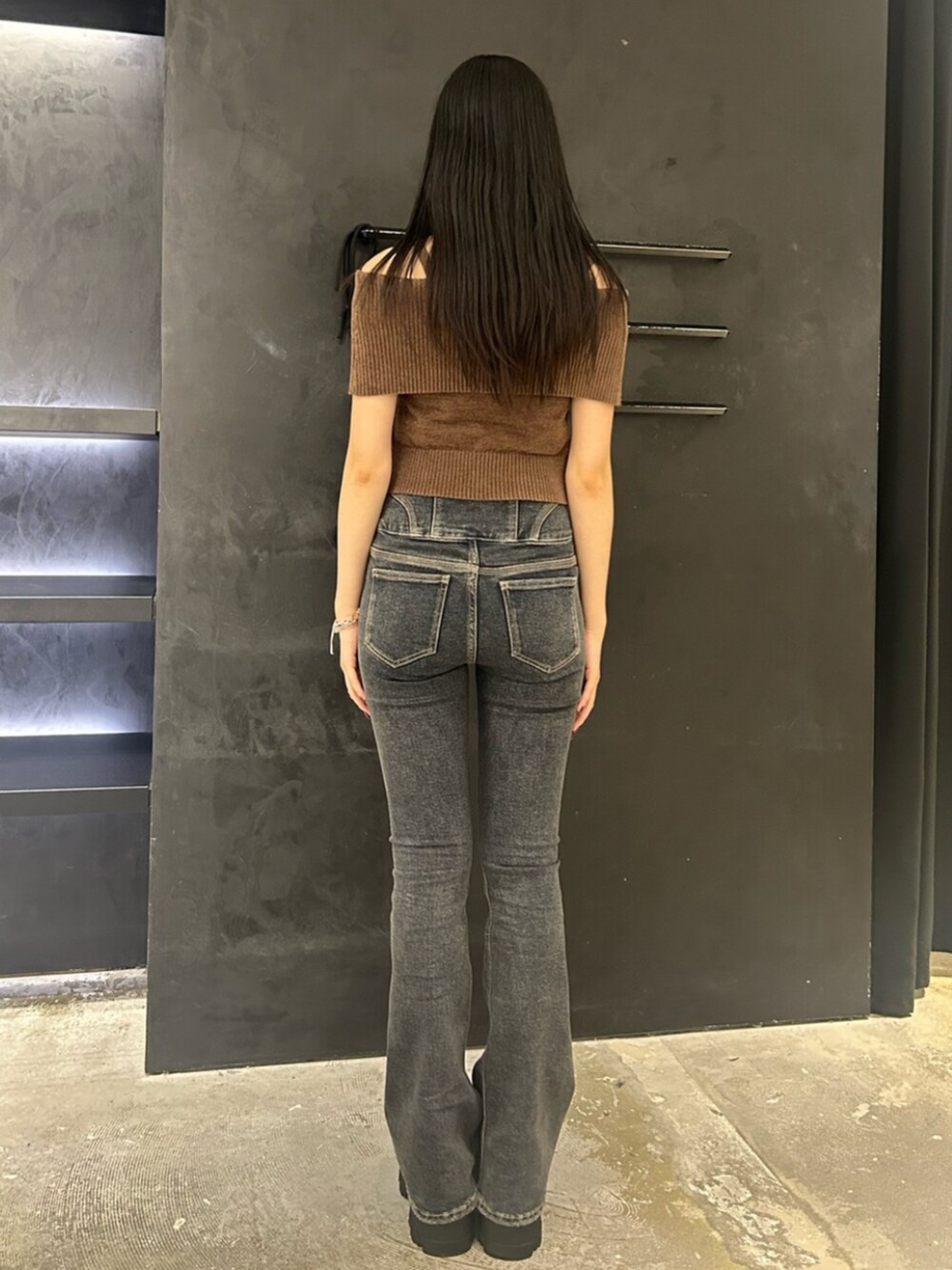 ブラウン系のブーツ、ブラウン系のニット/セーター、ブルー系のデニムパンツを着用したレディースの夏コーディネートの3枚目の写真