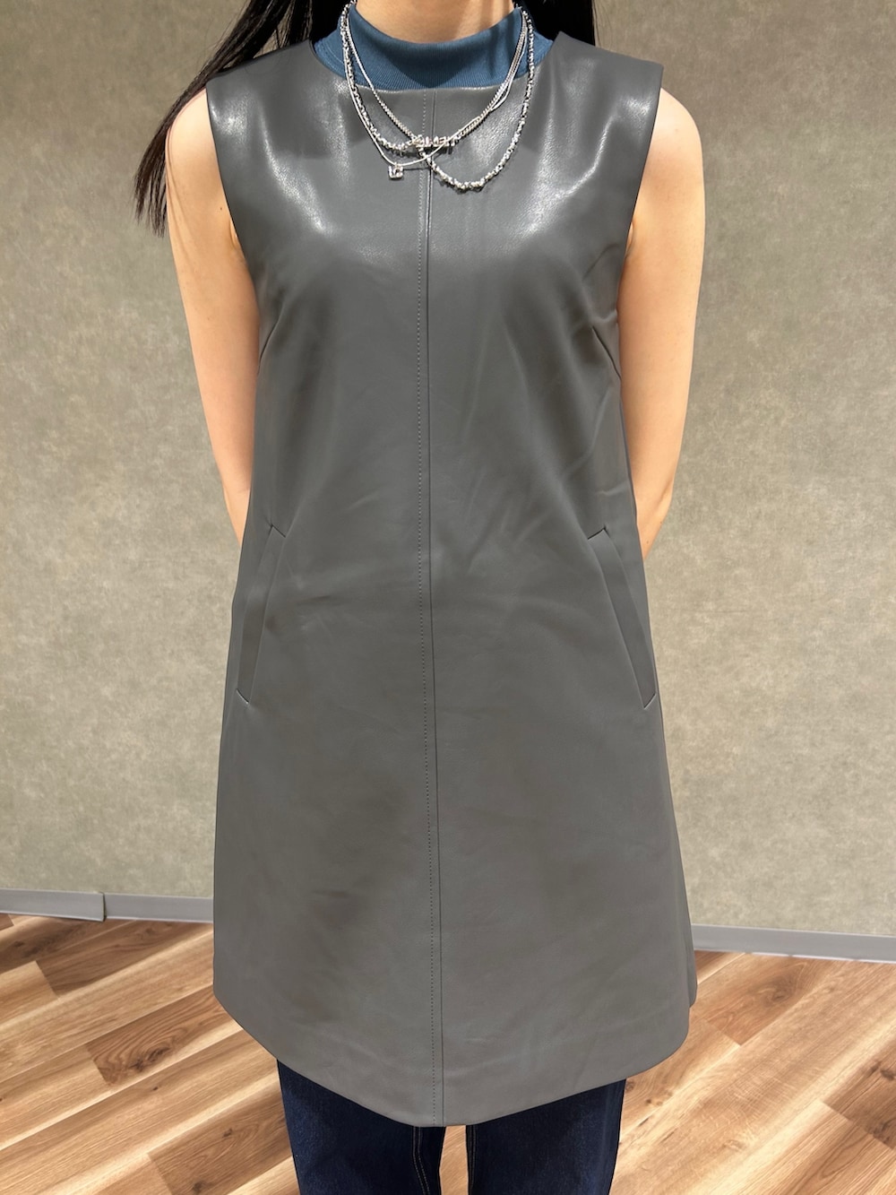 グレー系のワンピース、グレー系のハンドバッグ、ブルー系のデニムパンツを着用したレディースの夏コーディネートの6枚目の写真