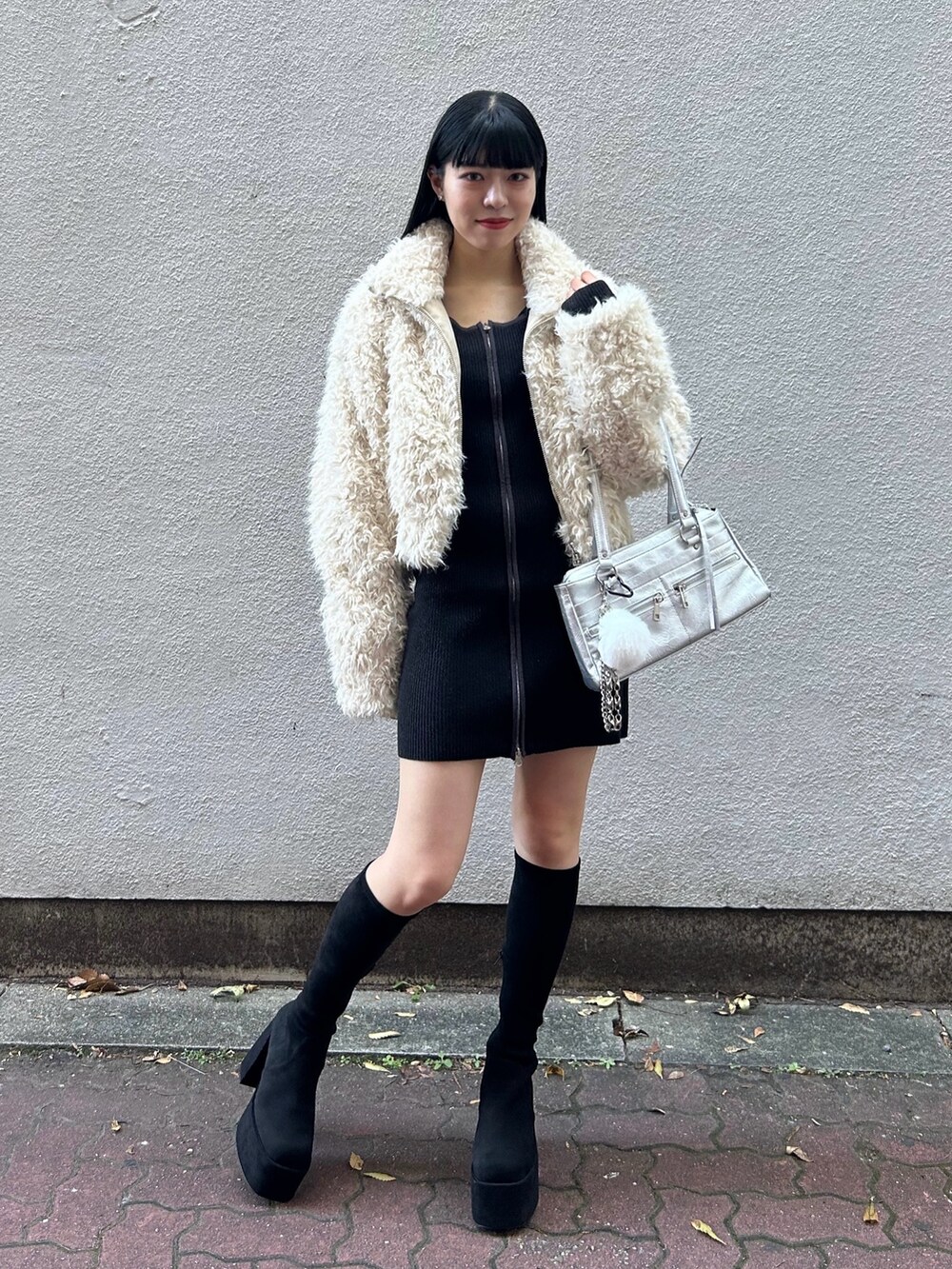 ホワイト系のブルゾン、ブラック系のワンピース、シルバー系のショルダーバッグを着用したレディースの秋コーディネートの2枚目の写真