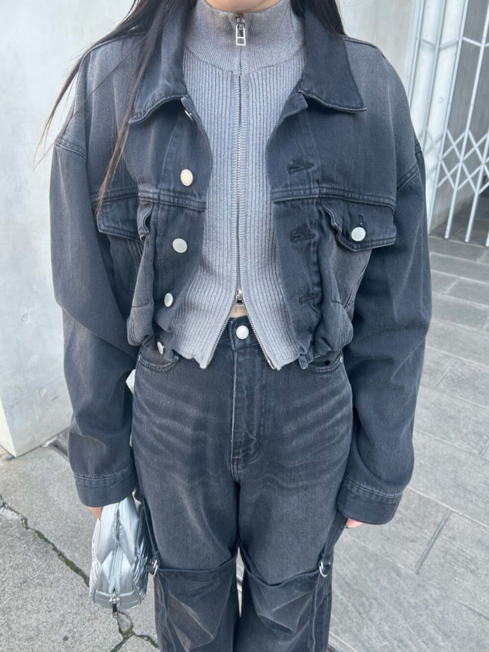 ブラック系のブーツ、ブラック系のデニムジャケット、ブラック系のデニムパンツを着用したレディースの冬コーディネートの5枚目の写真